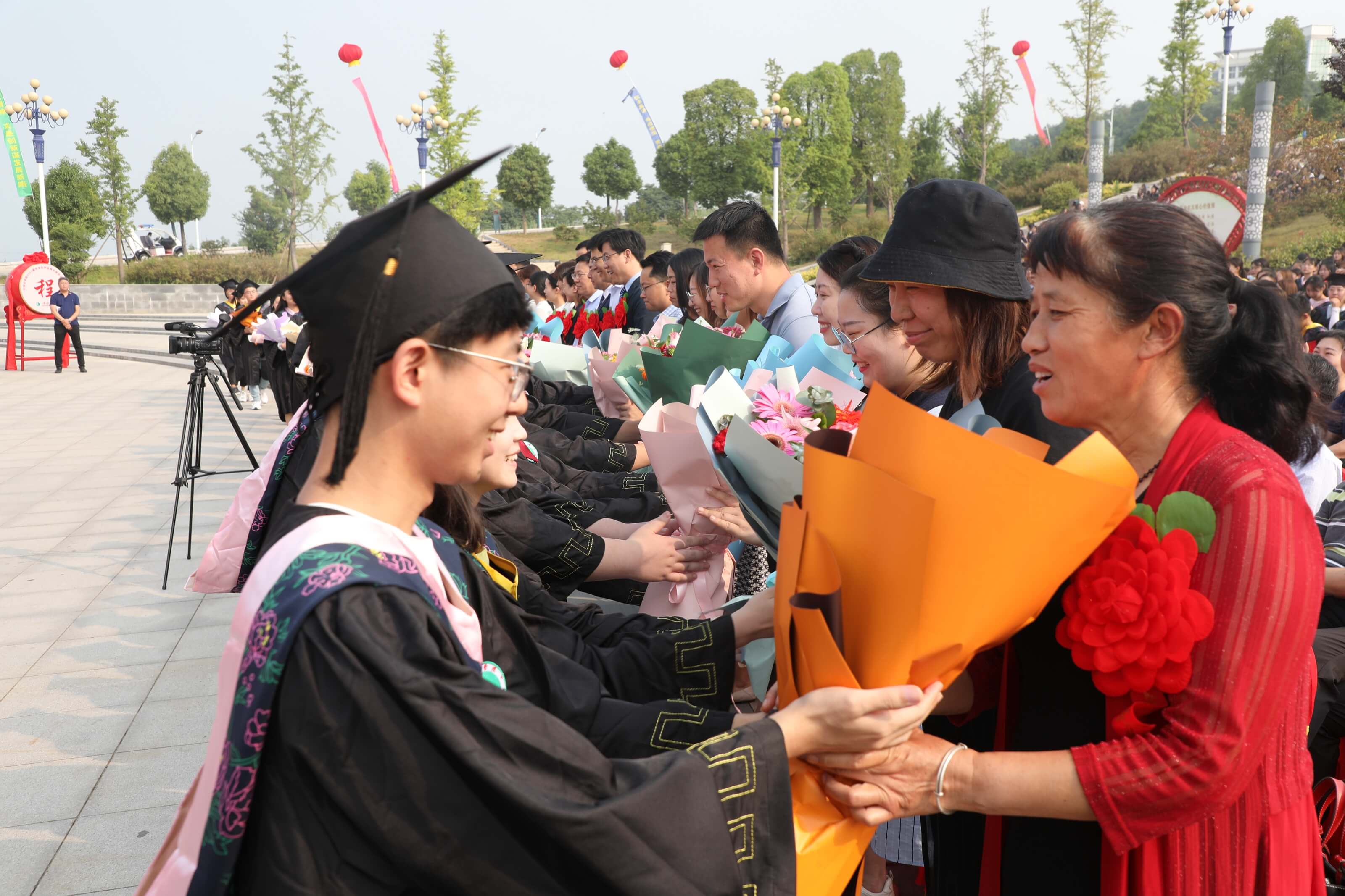 毕业生代表向教职工代表、家长代表献花(摄影陈留彪)