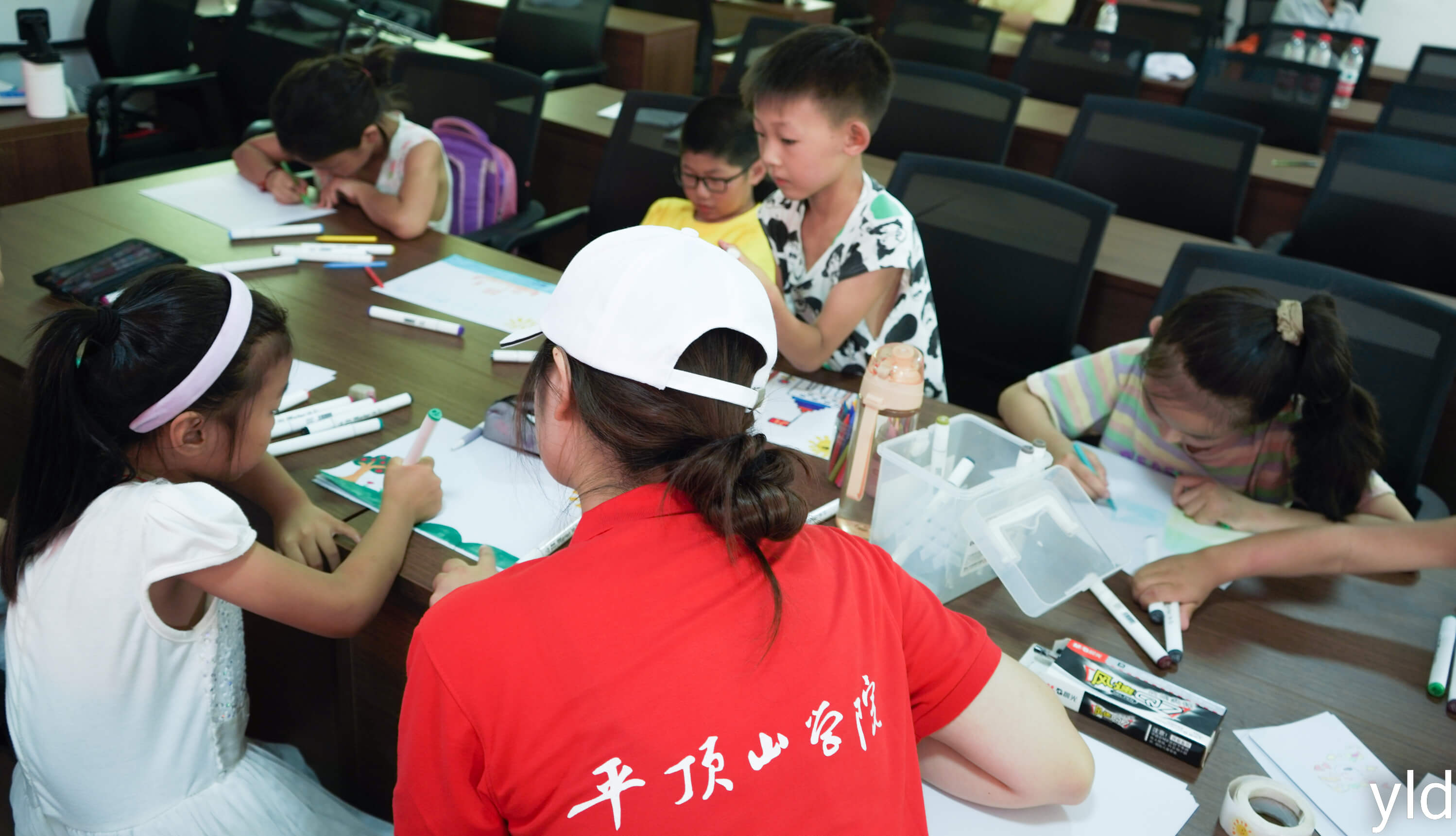 图为志愿者教小朋友进行绘画。 范雨欣 摄