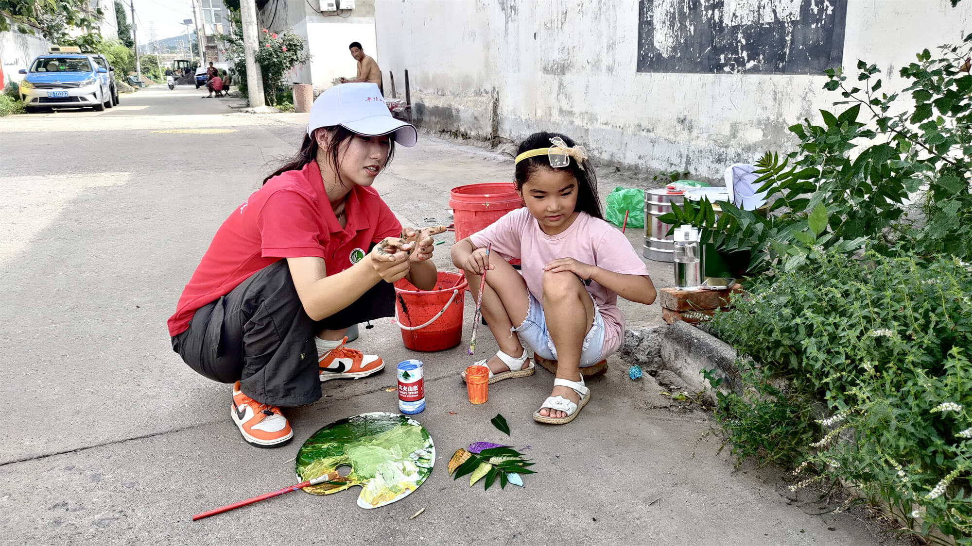 图为小朋友和志愿者进行墙绘的准备工作。 张军昊 摄