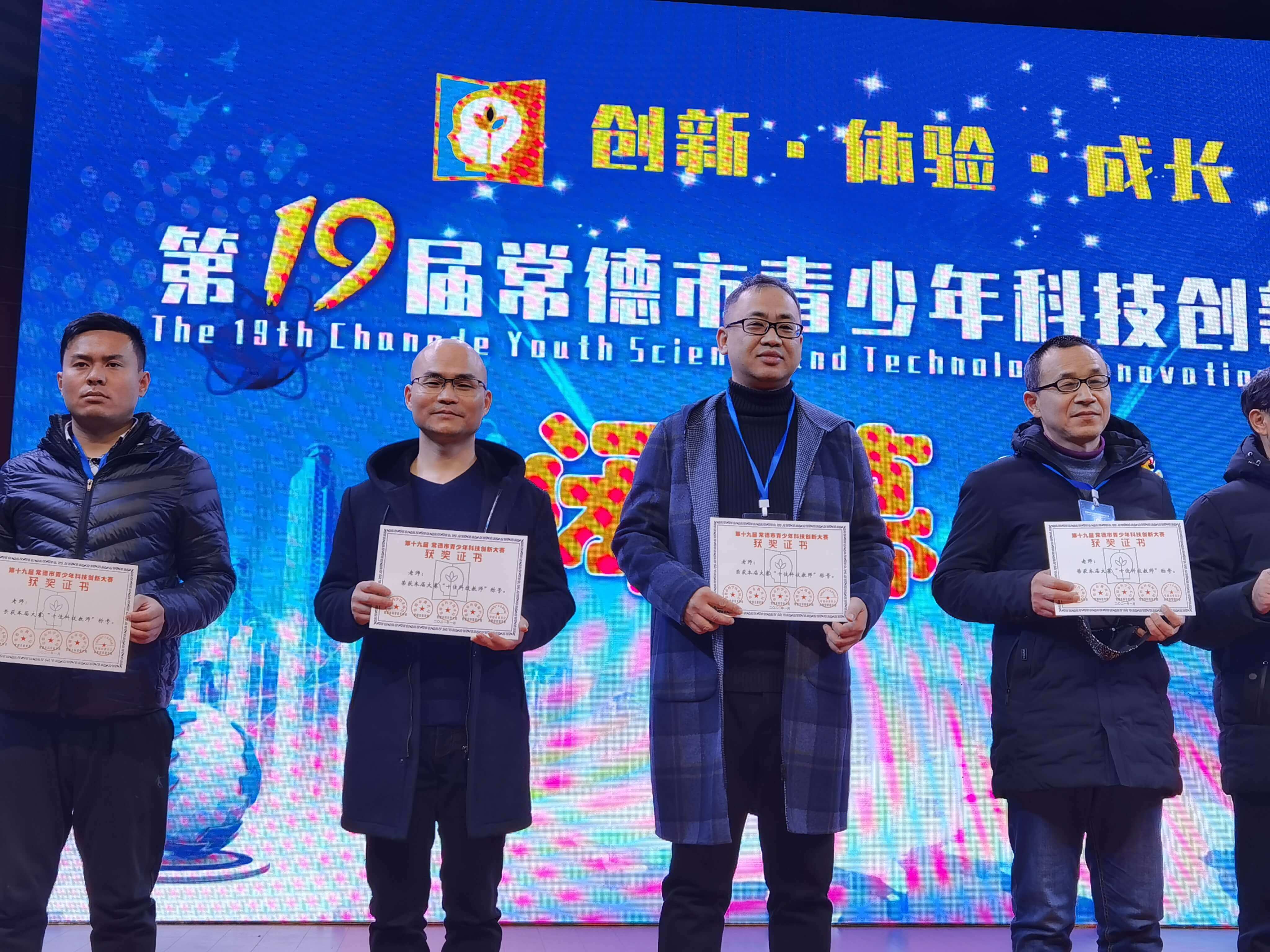 覃毅(左三)获“十佳科技教师”奖